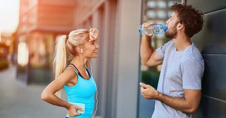 Fit young couple on a break from running outside city building